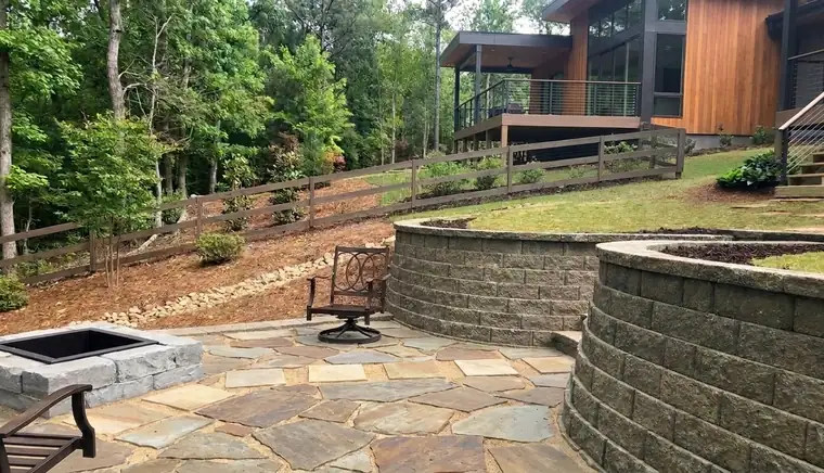 Curved block retaining walls around a flagstone fire pit patio in Atlanta GA