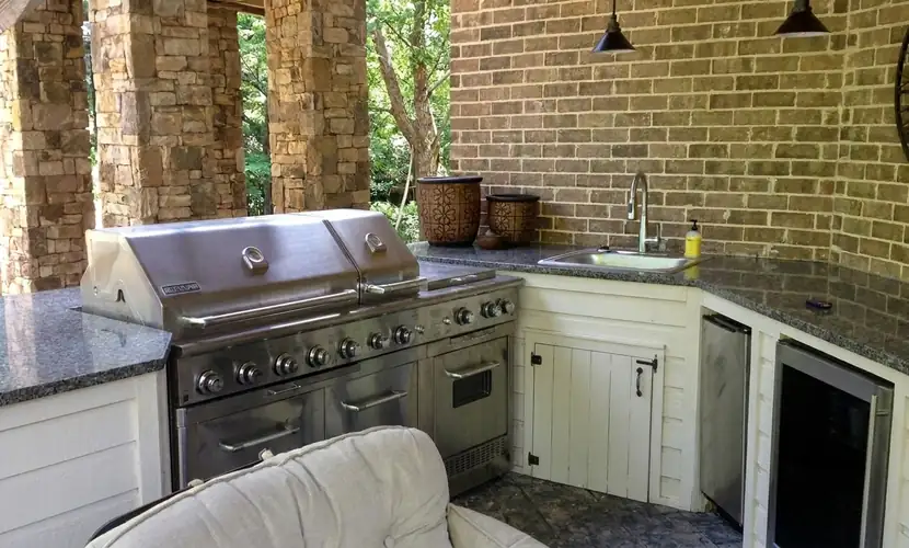 Outdoor kitchen with built-in grill, granite counters and sink in Atlanta