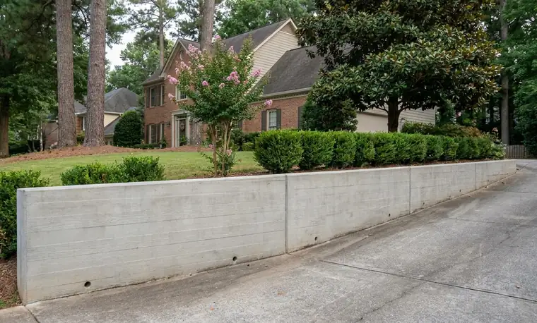 Board-formed concrete retaining wall along a driveway in Atlanta GA