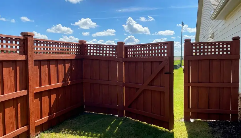 Stained wood privacy fence with lattice top and double gate in Atlanta GA
